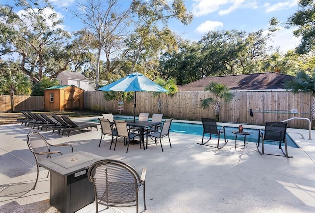 view of patio / terrace with a storage shed, an outbuilding, a fenced backyard, and a fenced in pool