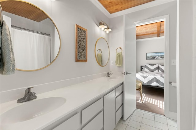 ensuite bathroom featuring double vanity, wooden ceiling, ornamental molding, tile patterned flooring, and a sink