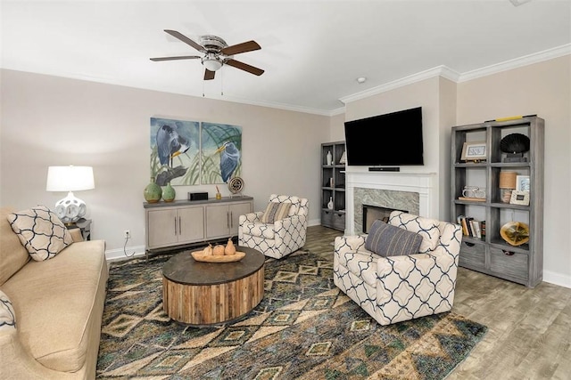 living room featuring hardwood / wood-style floors, crown molding, a premium fireplace, and ceiling fan