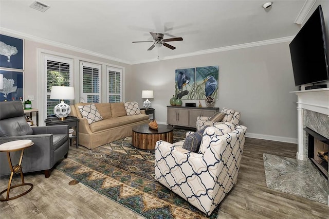 living room featuring a premium fireplace, wood-type flooring, and crown molding