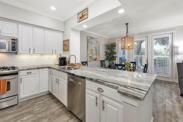 kitchen featuring appliances with stainless steel finishes, sink, white cabinets, and kitchen peninsula