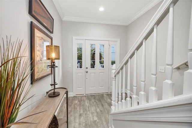 foyer with ornamental molding and light hardwood / wood-style flooring