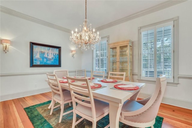 dining space featuring a notable chandelier, wood-type flooring, and ornamental molding