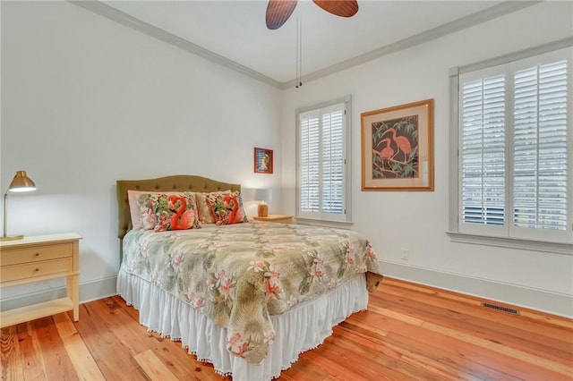 bedroom with ceiling fan, ornamental molding, and wood-type flooring