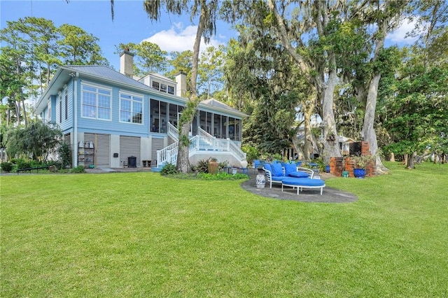 back of property featuring cooling unit, a yard, and a sunroom