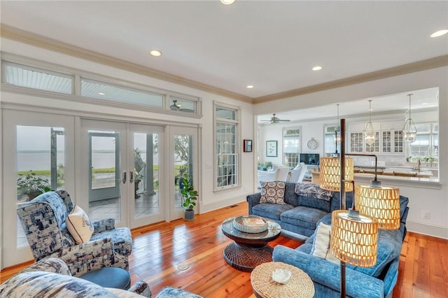 living room featuring ornamental molding, light hardwood / wood-style flooring, and french doors