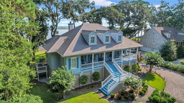 exterior space with a water view, covered porch, and a lawn