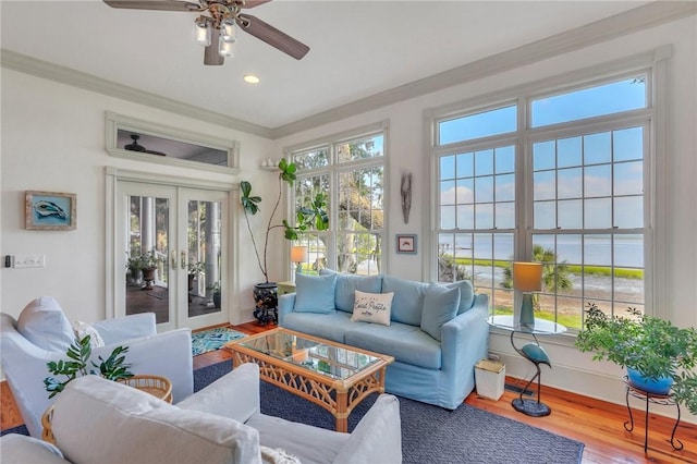 sunroom featuring a water view, ceiling fan, plenty of natural light, and french doors