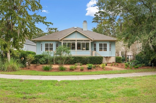 23 W Lake Dr, Saint Simons Island, GA 31522 - ranch-style home featuring a sunroom, a front yard, and a chimney