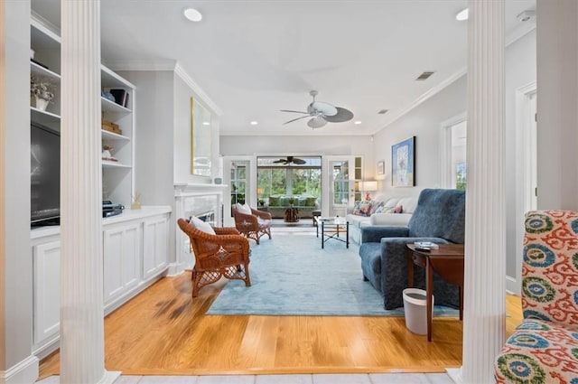 living room featuring light hardwood / wood-style flooring, ceiling fan, and crown molding