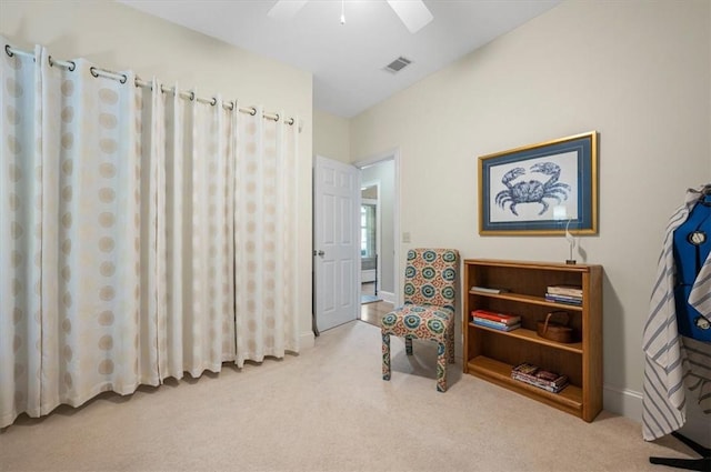 living area with light carpet and ceiling fan