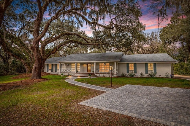 ranch-style house with a front yard and covered porch