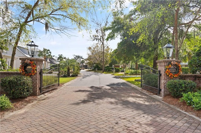 1045 Sinclair Pointe Pt, Saint Simons Island, GA 31522 - view of street with a gate and street lights