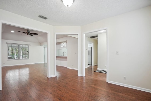 spare room featuring ceiling fan, sink, dark wood-type flooring, and a textured ceiling