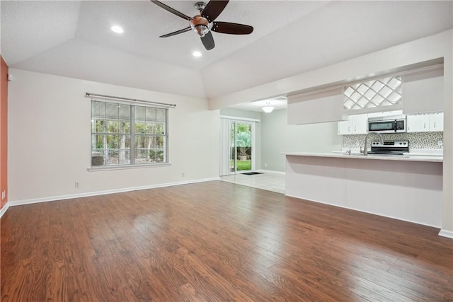 unfurnished living room featuring wood-type flooring, vaulted ceiling, and ceiling fan