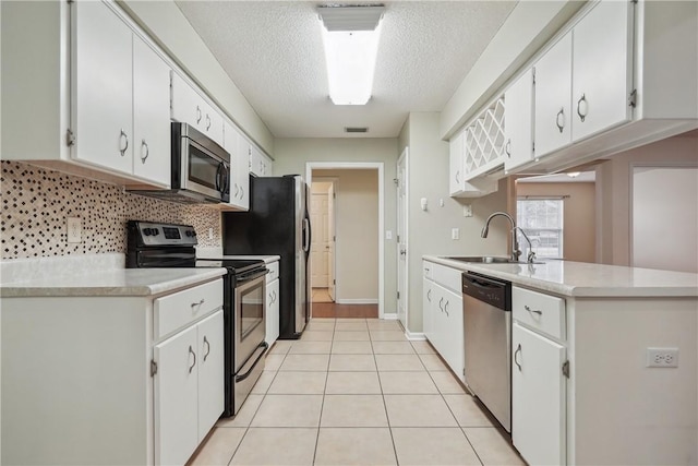 kitchen with white cabinetry, sink, light tile patterned floors, and appliances with stainless steel finishes