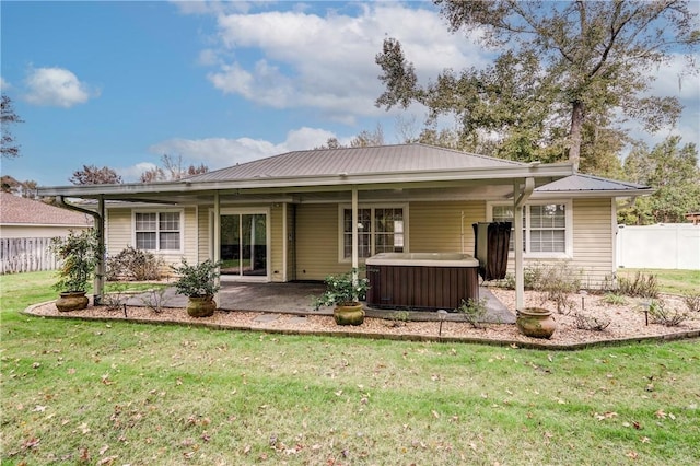 back of house with a lawn, a patio area, cooling unit, and a hot tub