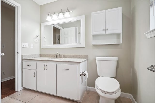 bathroom with tile patterned flooring, vanity, and toilet