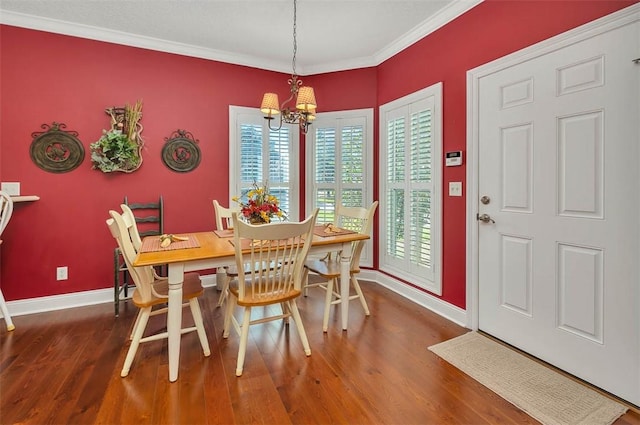 dining room with an inviting chandelier, dark wood-type flooring, and crown molding