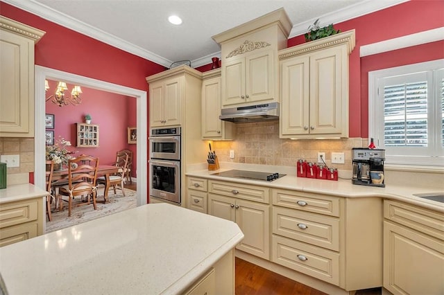 kitchen with black electric cooktop, ornamental molding, double oven, and cream cabinets