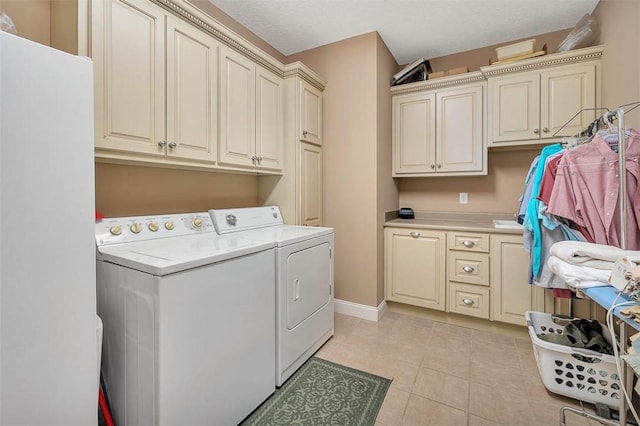 laundry area featuring washer and dryer, cabinets, light tile patterned floors, and a textured ceiling