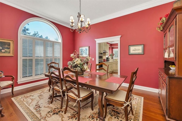 dining room featuring dark hardwood / wood-style floors, an inviting chandelier, and ornamental molding