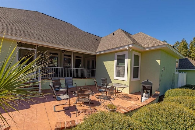 back of house featuring a fire pit and a patio