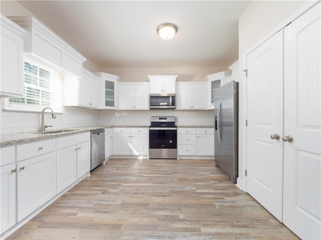 kitchen with white cabinets, light stone countertops, sink, and appliances with stainless steel finishes