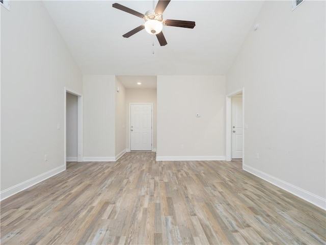 empty room with ceiling fan and light hardwood / wood-style flooring