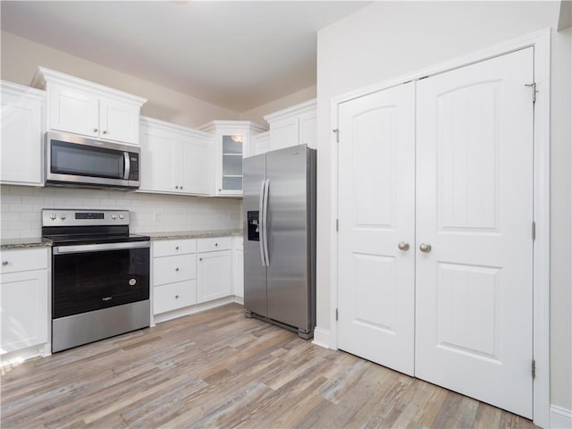 kitchen featuring white cabinets, stainless steel appliances, and light hardwood / wood-style floors