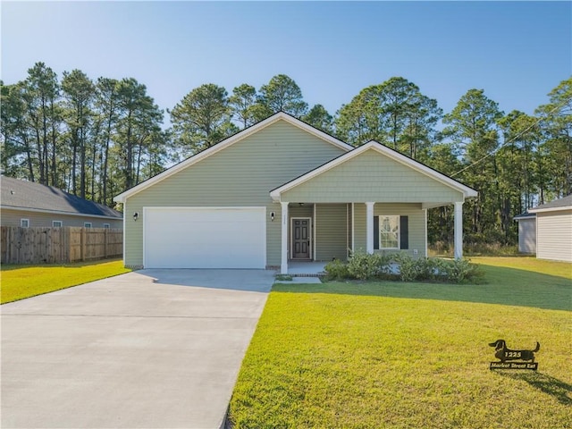 view of front of home featuring a front yard, a garage, and covered porch