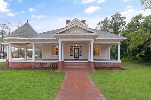 view of front facade featuring ceiling fan, a porch, and a front lawn