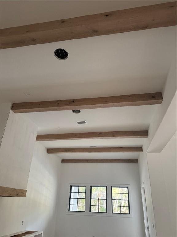 hallway featuring visible vents and beamed ceiling