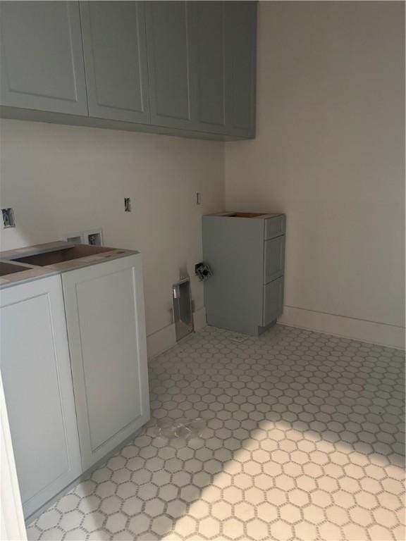 clothes washing area with cabinet space, baseboards, washer / clothes dryer, and light floors