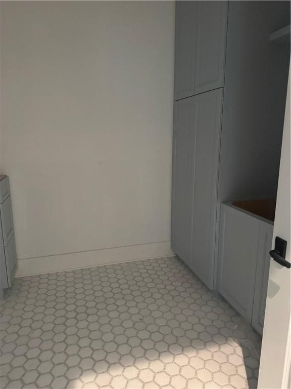 laundry area with light floors and baseboards