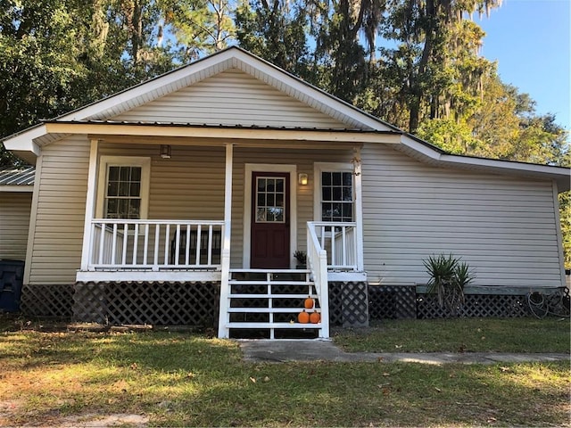 bungalow featuring covered porch and a front yard