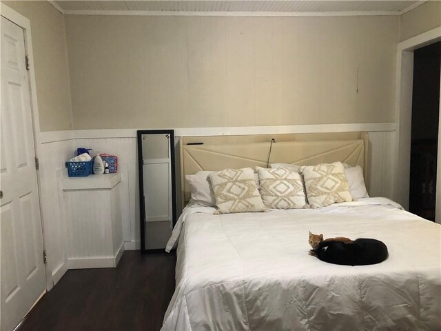 bedroom with dark hardwood / wood-style flooring and crown molding