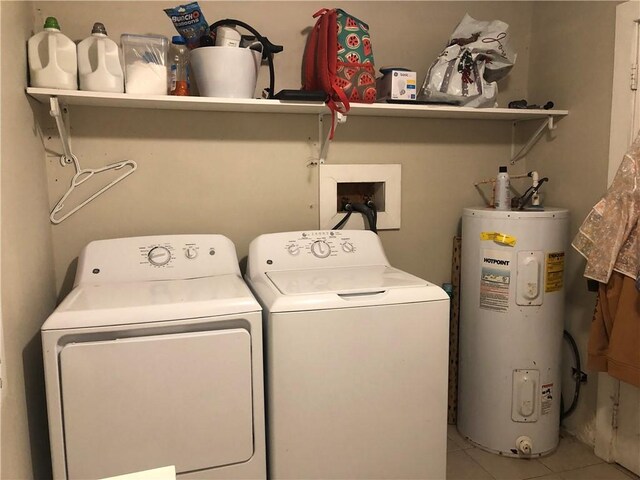 laundry room featuring light tile patterned floors, washer and clothes dryer, and water heater