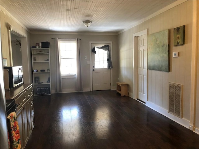 entryway featuring ornamental molding, dark hardwood / wood-style floors, and wooden walls