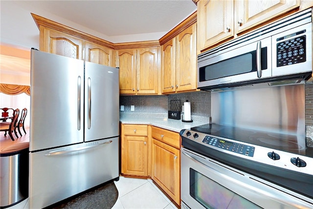 kitchen featuring stainless steel appliances, tasteful backsplash, and light tile patterned flooring