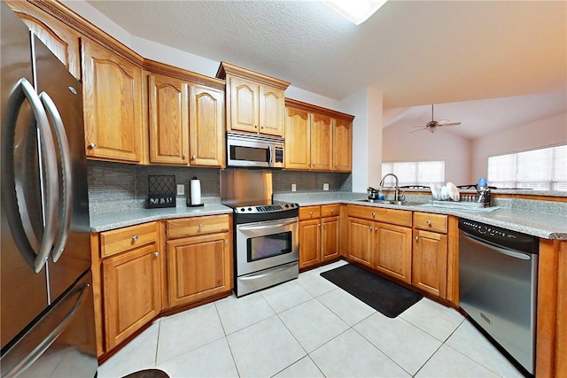 kitchen featuring backsplash, sink, lofted ceiling, and stainless steel appliances