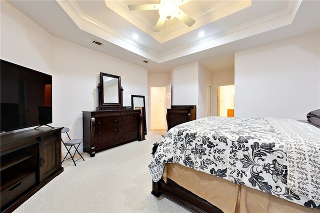 carpeted bedroom featuring ceiling fan, ornamental molding, and a tray ceiling