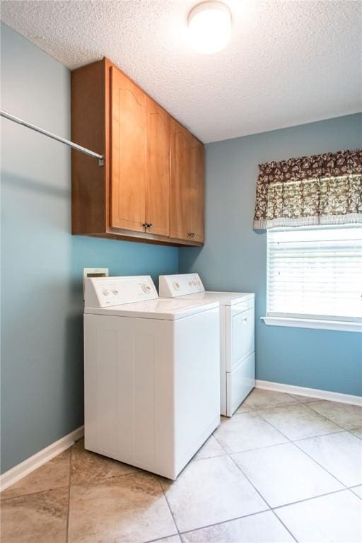 1709 Suwanne Dr, Waycross, GA 31501 - laundry room featuring a textured ceiling, washing machine and dryer, cabinet space, baseboards, and light tile patterned floors