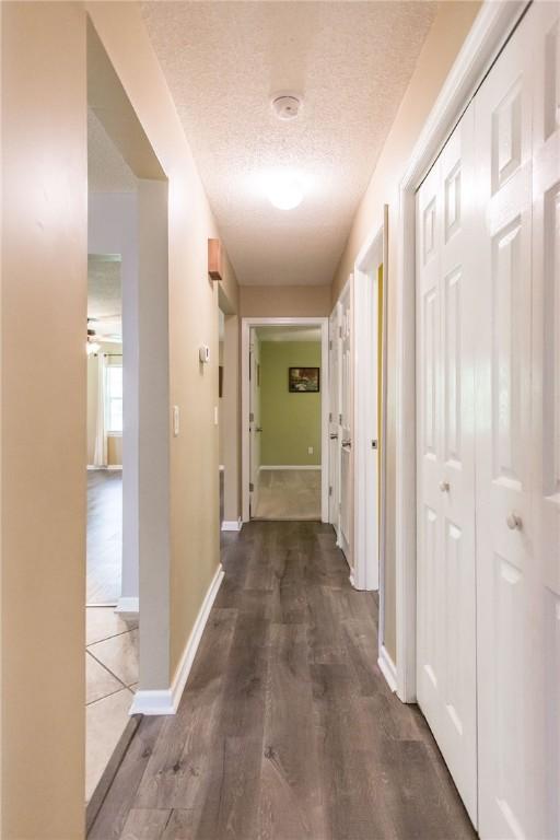 1709 Suwanne Dr, Waycross, GA 31501 - hall with a textured ceiling, baseboards, and wood finished floors