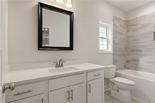 full bathroom with tiled shower / bath, vanity, and toilet