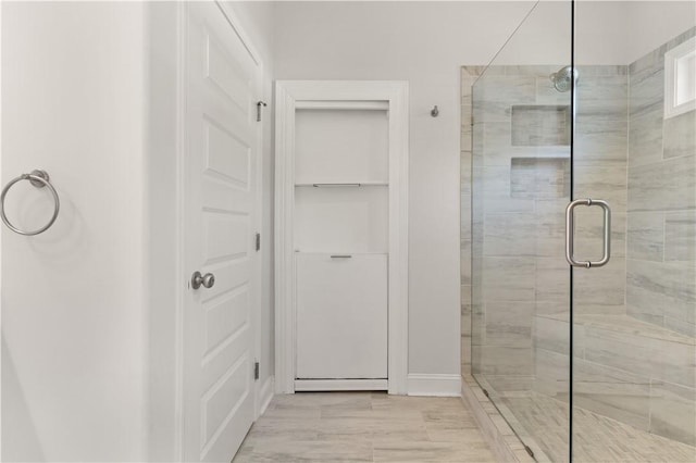 bathroom with wood-type flooring and a shower with door