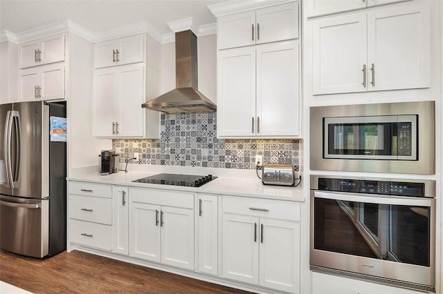 kitchen with appliances with stainless steel finishes, dark hardwood / wood-style flooring, white cabinetry, and wall chimney exhaust hood