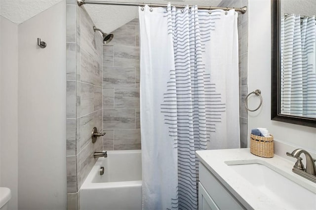 full bathroom with vanity, toilet, shower / bath combo with shower curtain, and a textured ceiling