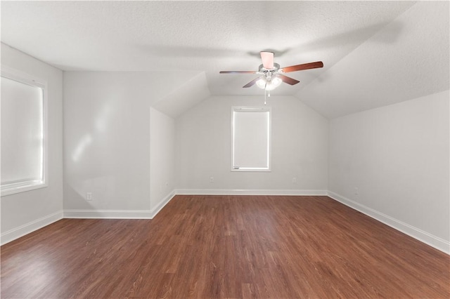 bonus room with dark hardwood / wood-style floors, ceiling fan, a textured ceiling, and vaulted ceiling