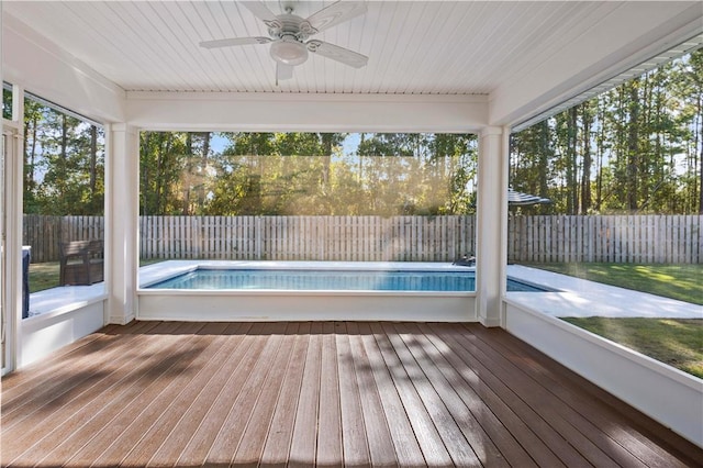 unfurnished sunroom with ceiling fan